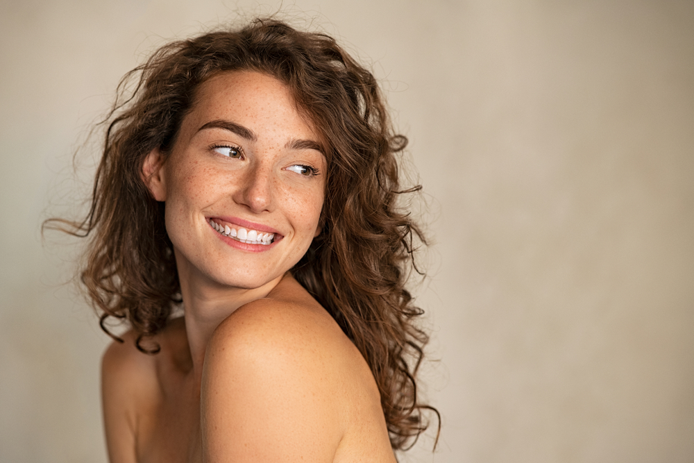 Portrait,Of,Smiling,Girl,Enjoying,Beauty,Treatment,On,Beige,Background. Moxi Laser Tampa
