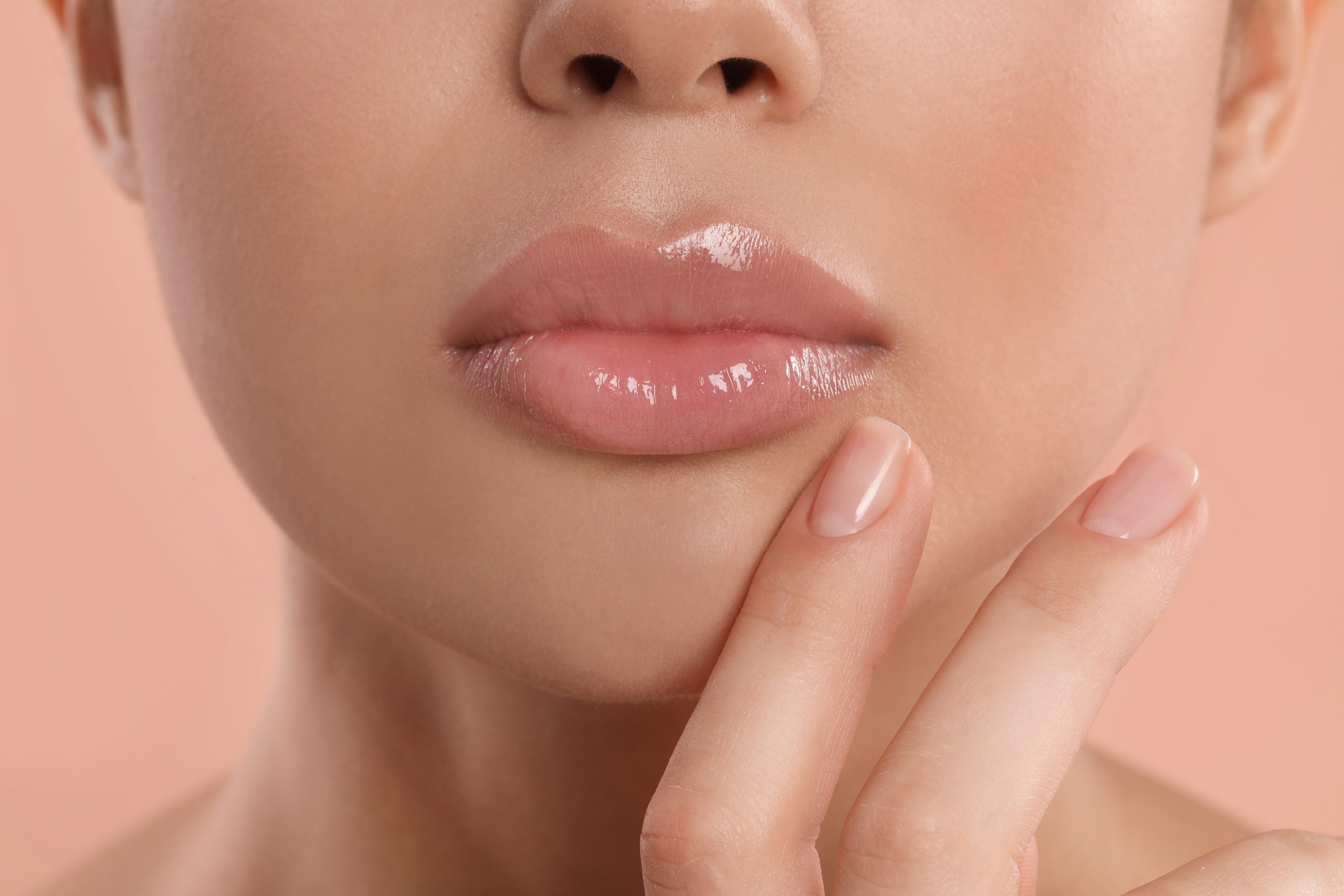 beautiful full lips with lip filler, Young woman with beautiful full lips on peach background, closeup