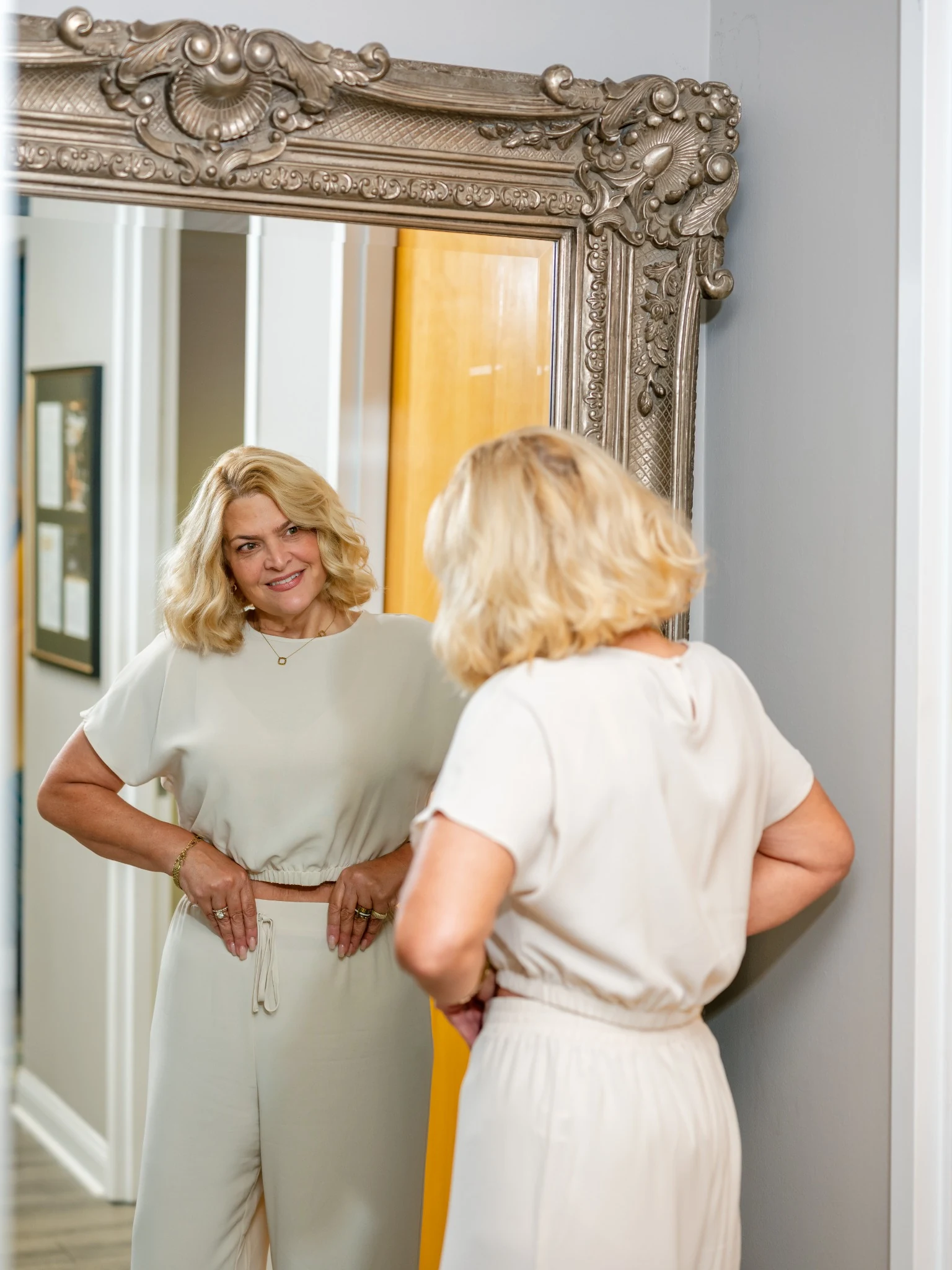 Patient reviewing weight loss transformation results in mirror during summertime weight loss consultation at Tampa Bay Total Wellness